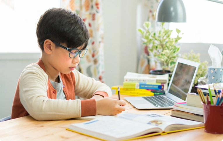 An EDUPRIZE Online student learning from home on a laptop with interactive class content.