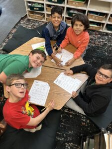 A young student reading a book with a teacher at an EDUPRIZE Arizona charter school